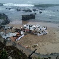 A broken up vessel on a beach. 